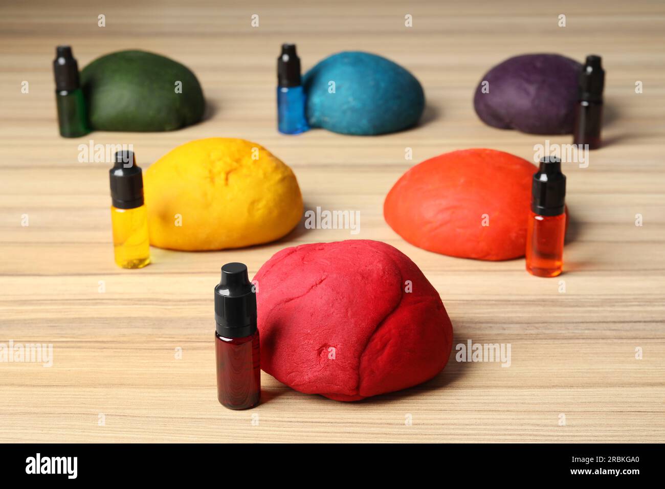 Colorful dough and bottles with food colorings on wooden table Stock Photo