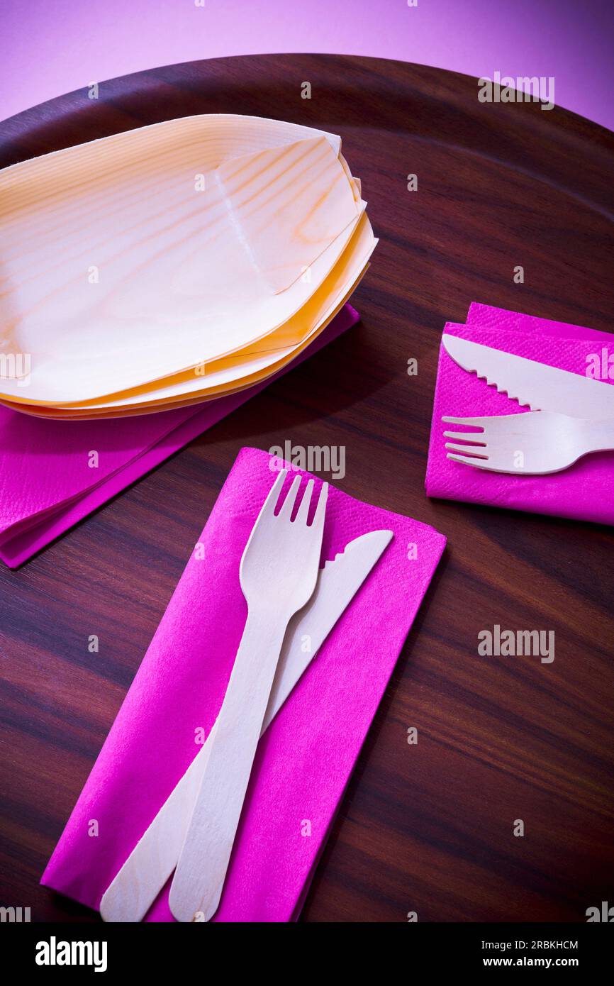 Eco-friendly wooden dishes and pink napkins on tray Stock Photo