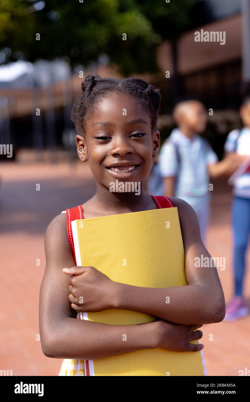 Portrait of happy african american schoolgirl standing in school yard ...