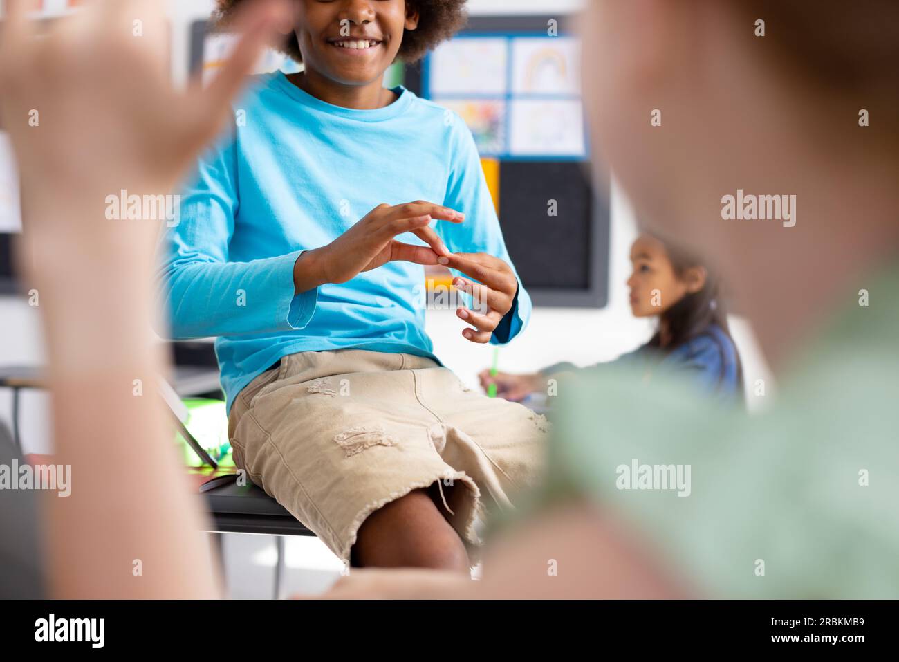 Happy diverse schoolchildren using sign language in school classroom Stock Photo Alamy