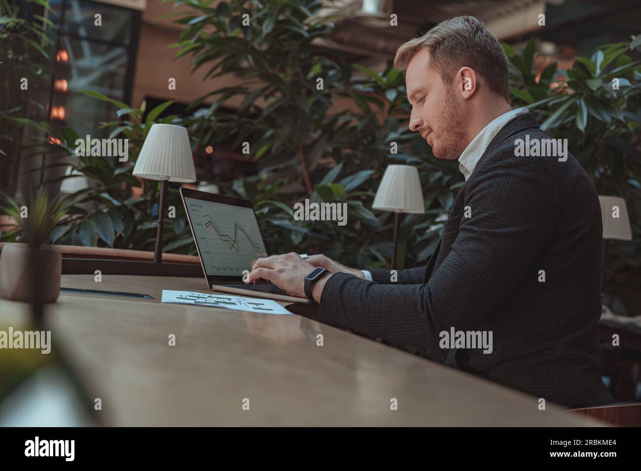 Focused businessman working with documents and use laptop while sitting in office Stock Photo