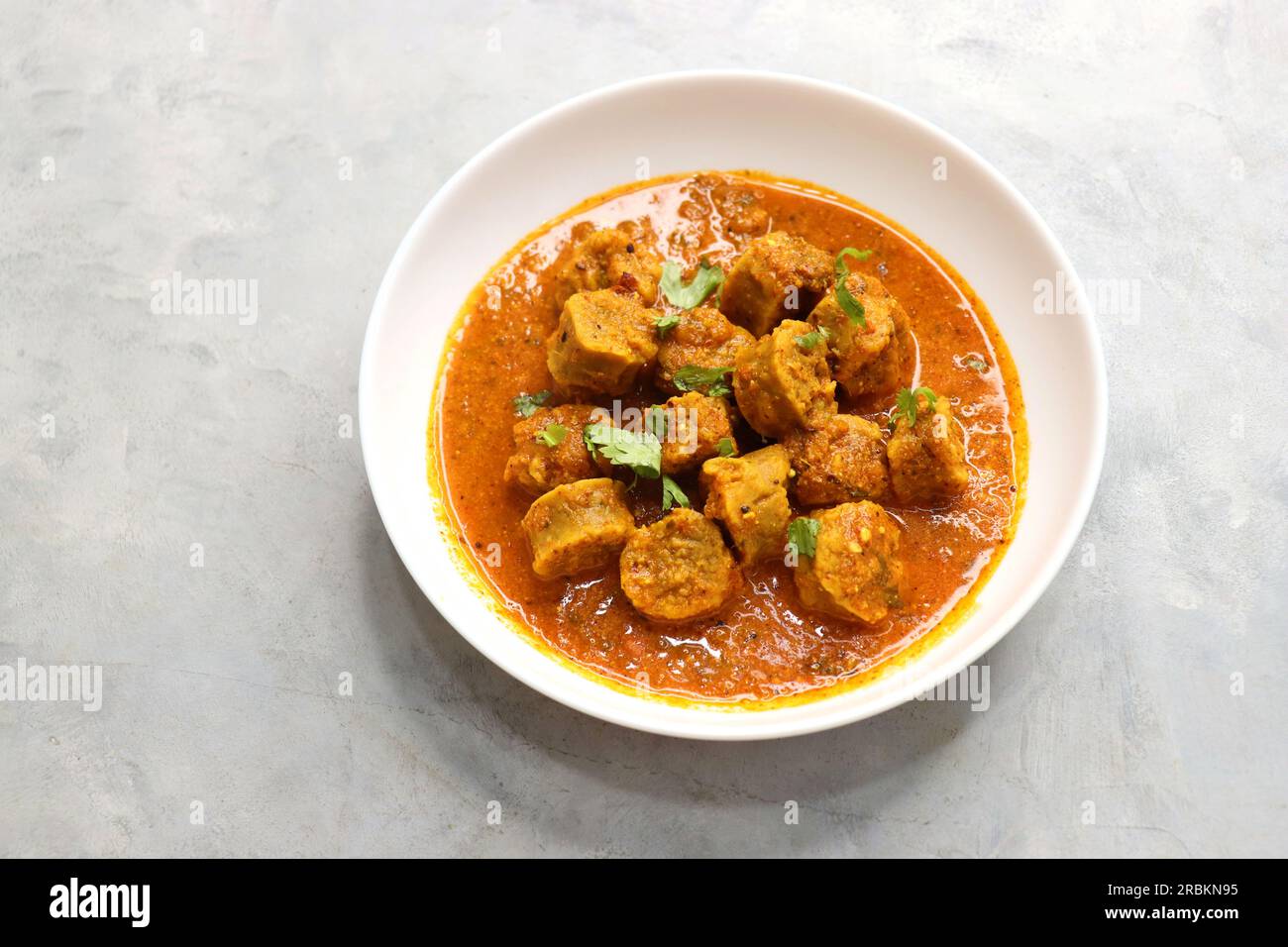 Rajasthani Gatta Curry or Besan Ke Gatte Ki Sabzi. Gatte are gram flour roundels or chickpea flour dumplings are cooked in a spicy, tangy yogurt curry Stock Photo