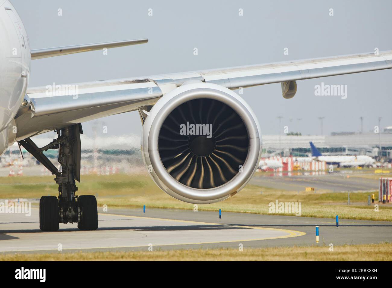 Hot air behind jet engine of plane at airport. Airplane is taxiing to runway for take off during sunny summer day. Stock Photo