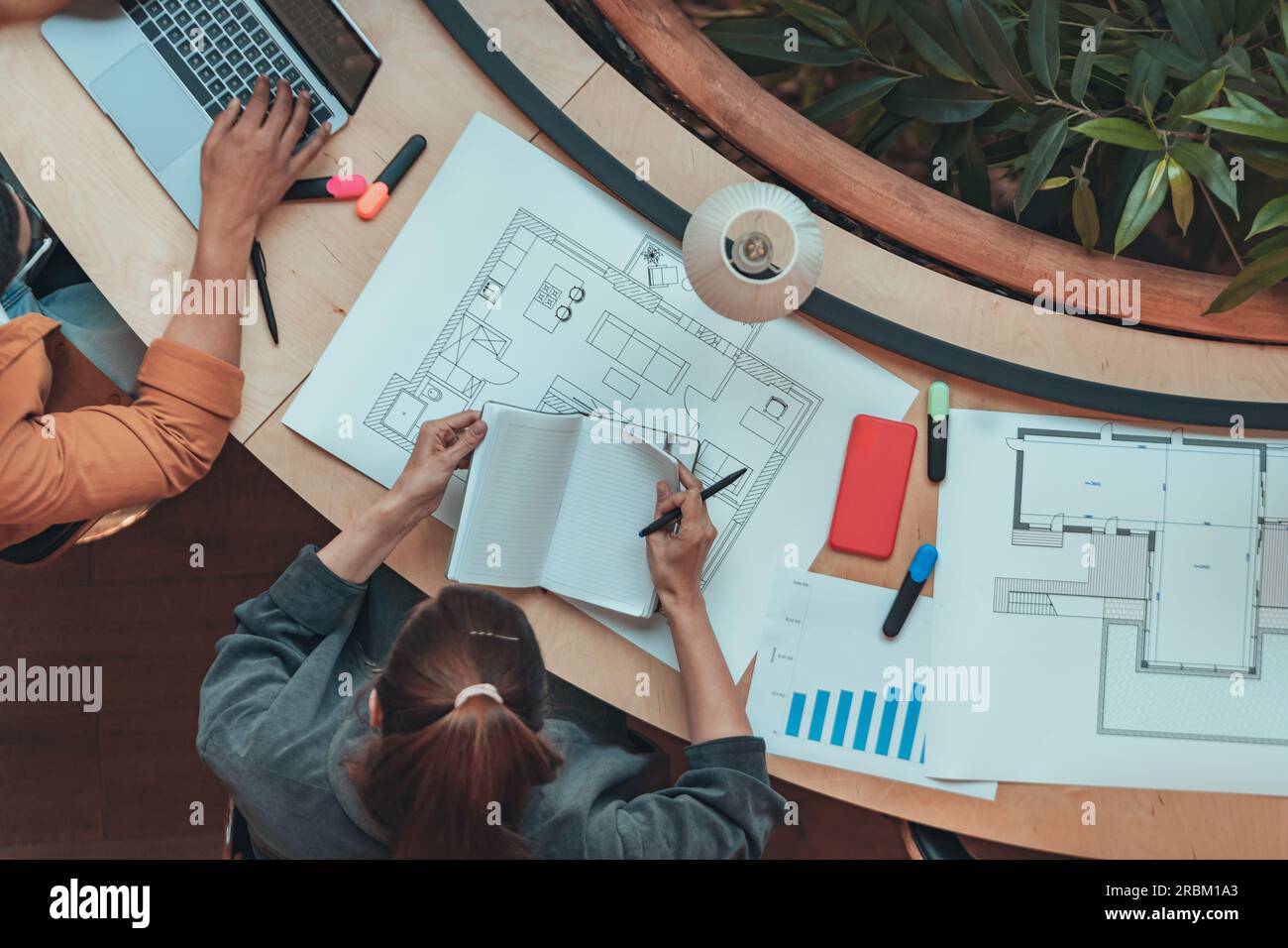 Top view of female architect engineer making notes during work with a construction project Stock Photo
