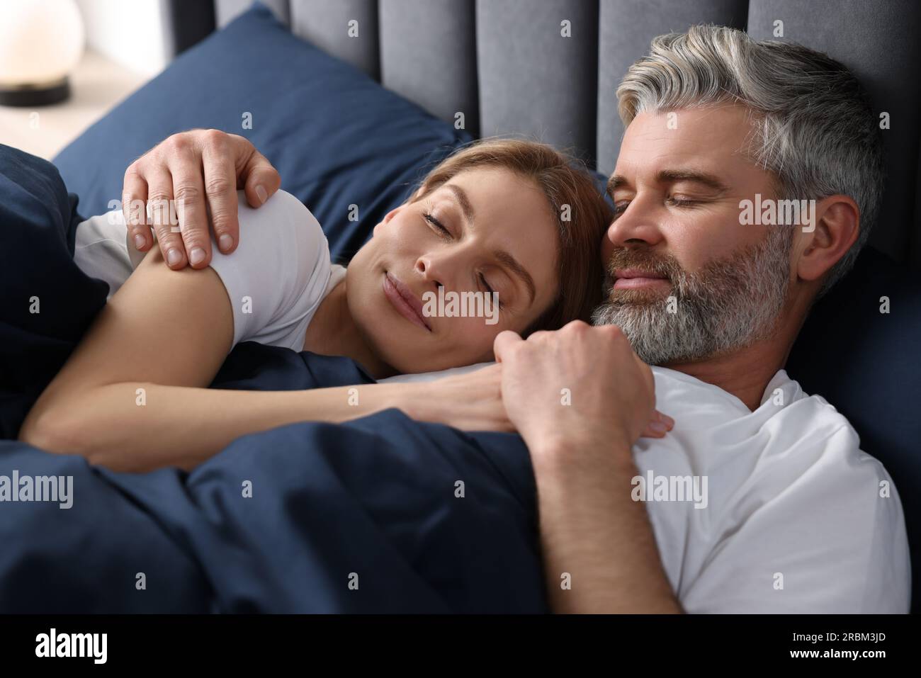 Lovely mature couple sleeping together in bed at home Stock Photo - Alamy