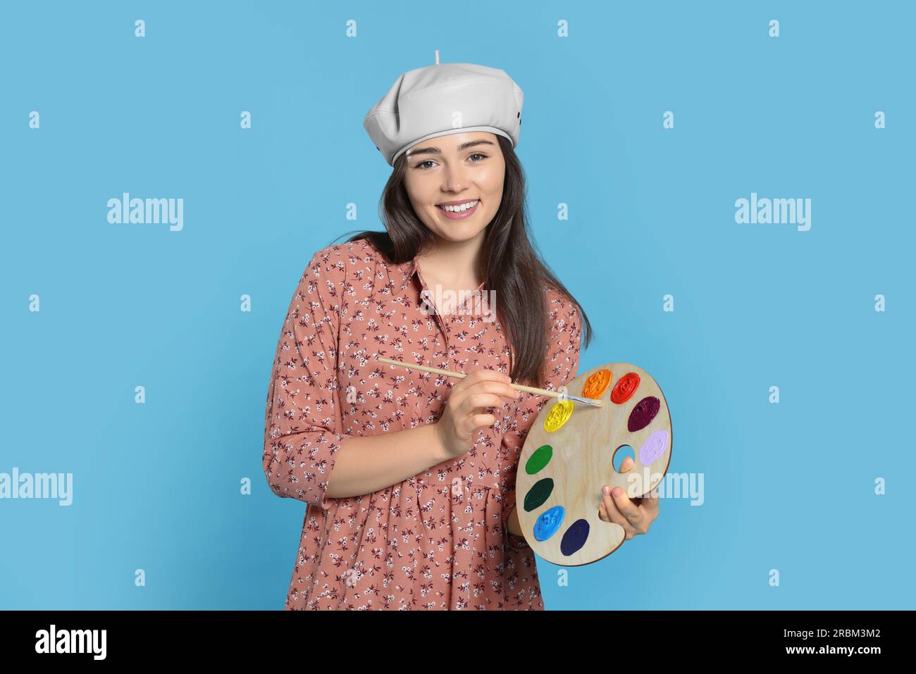 Woman with painting tools on light blue background. Young artist Stock ...