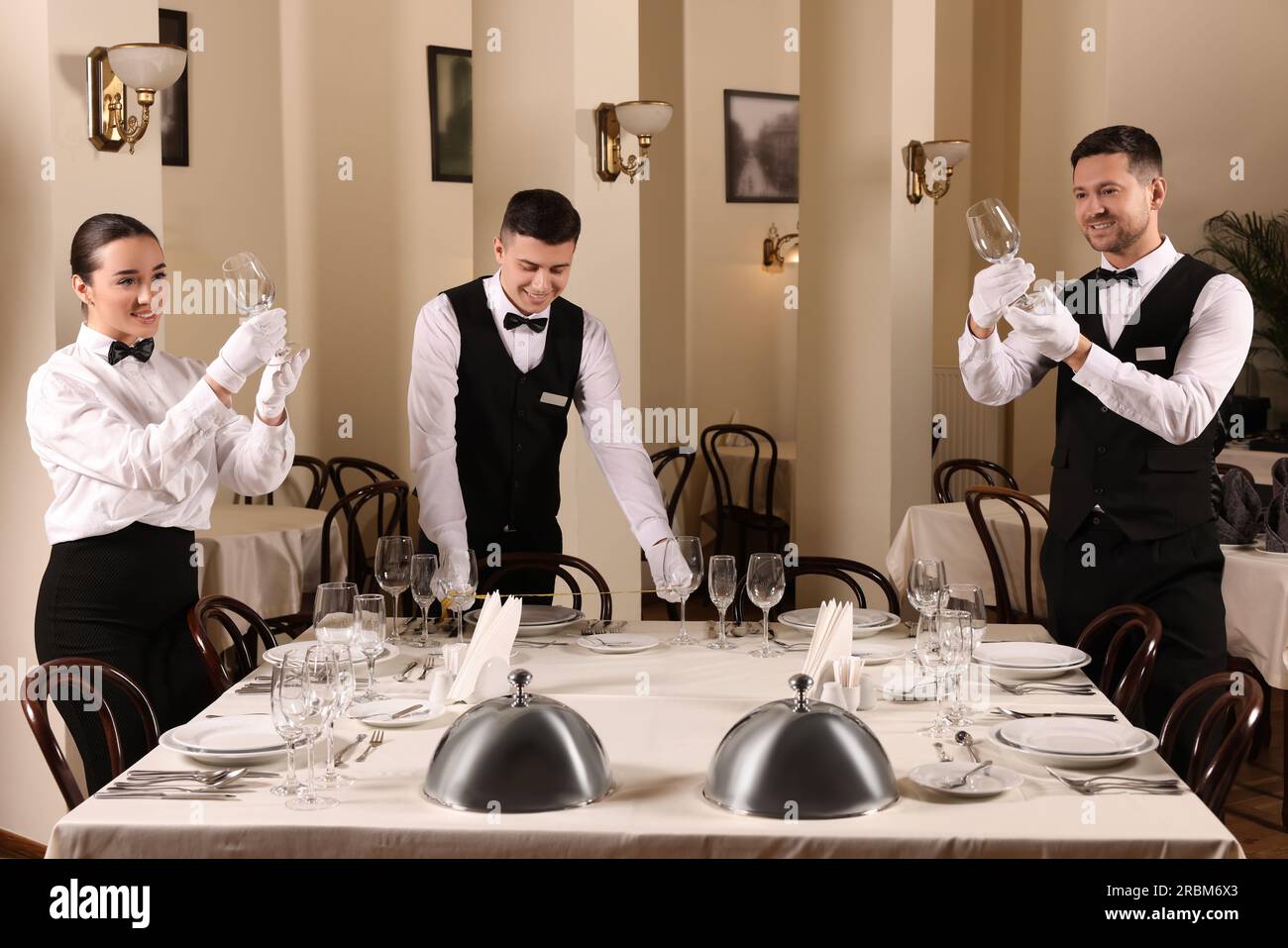 Group of people learning how to set table during professional butler Group of people learning how to set table during professional butler
