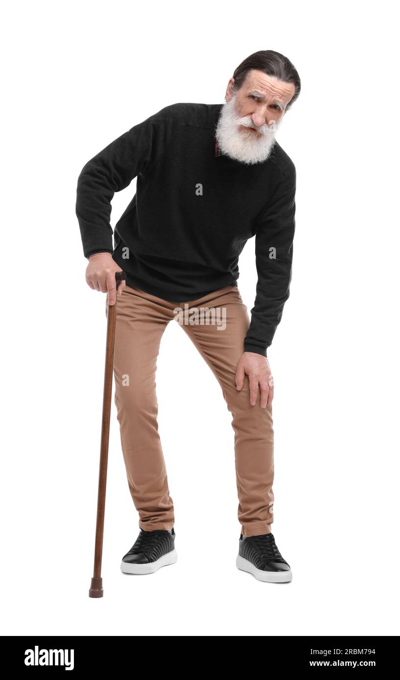 Senior man with walking cane suffering from knee pain on white