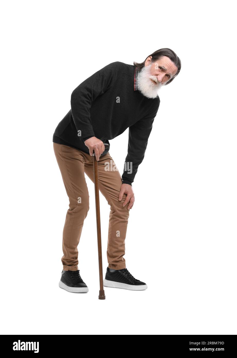 Senior man with walking cane suffering from knee pain on white