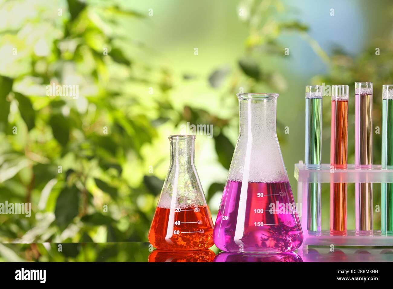 Laboratory glassware and test tubes with colorful liquids on glass ...