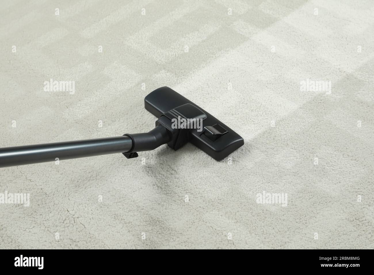 Hoovering carpet with vacuum cleaner. Clean trace on dirty surface