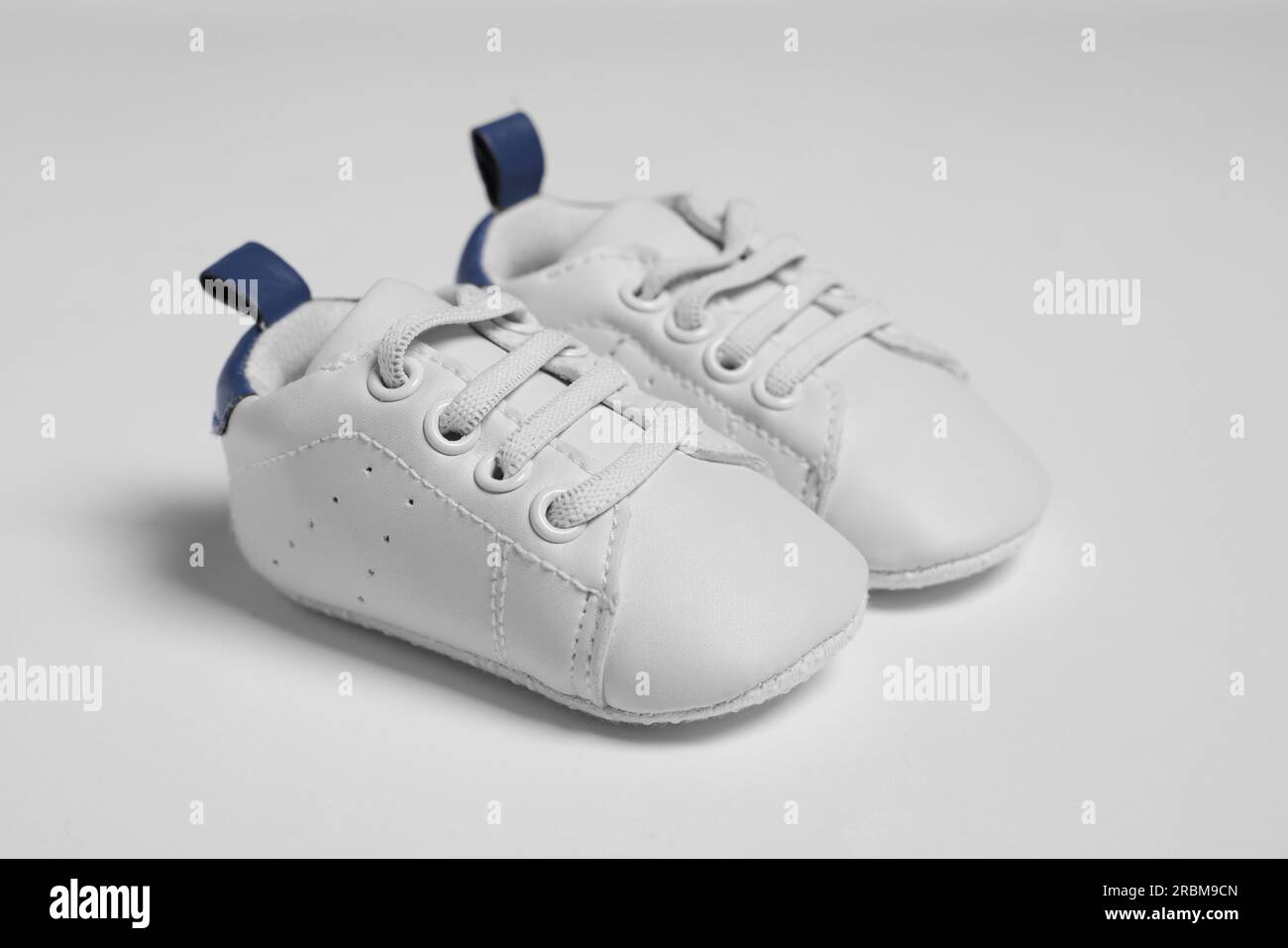 Pair of cute baby shoes on white background Stock Photo - Alamy