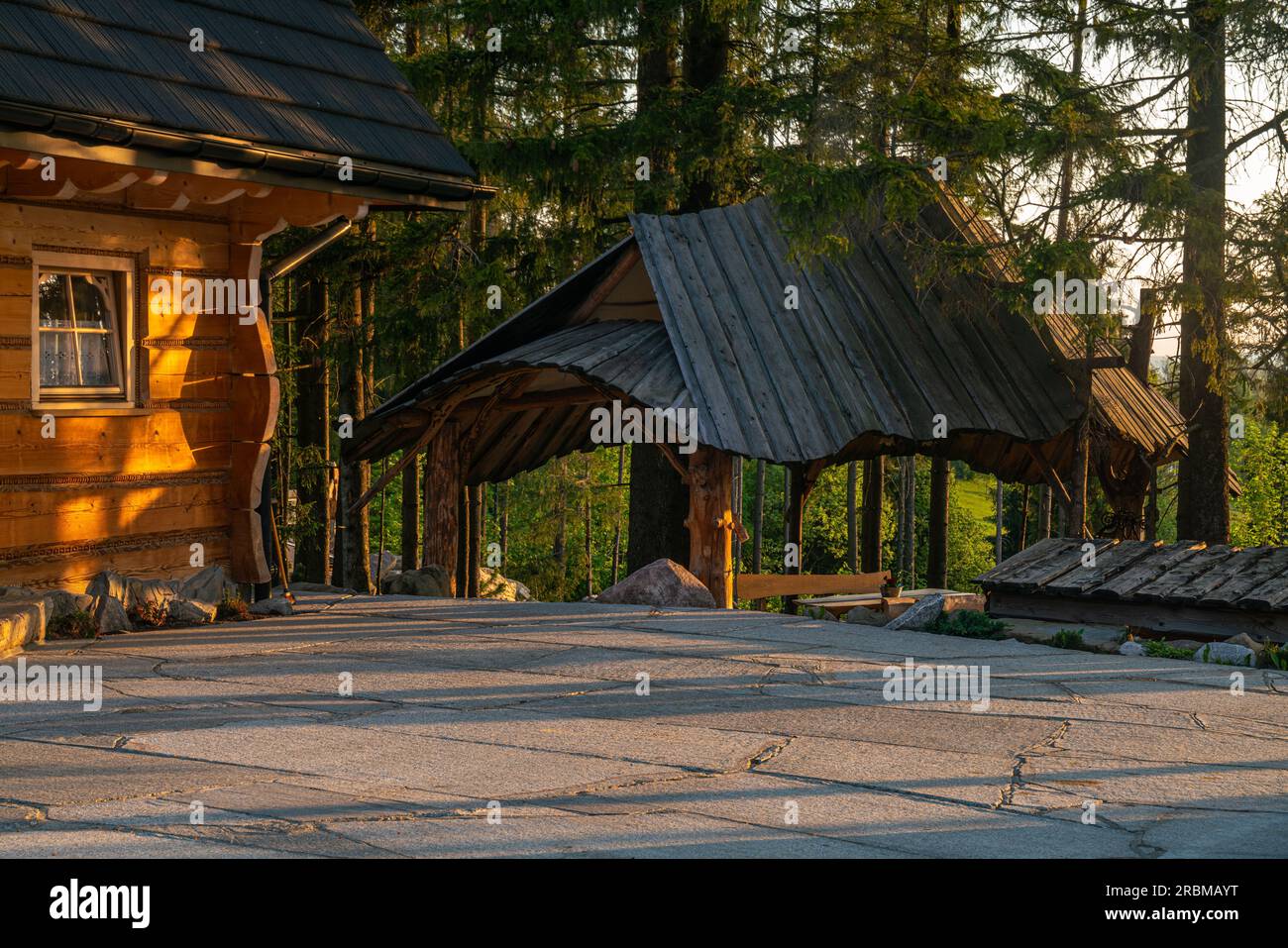Stone car park in front of a mountain house in the light of the rising