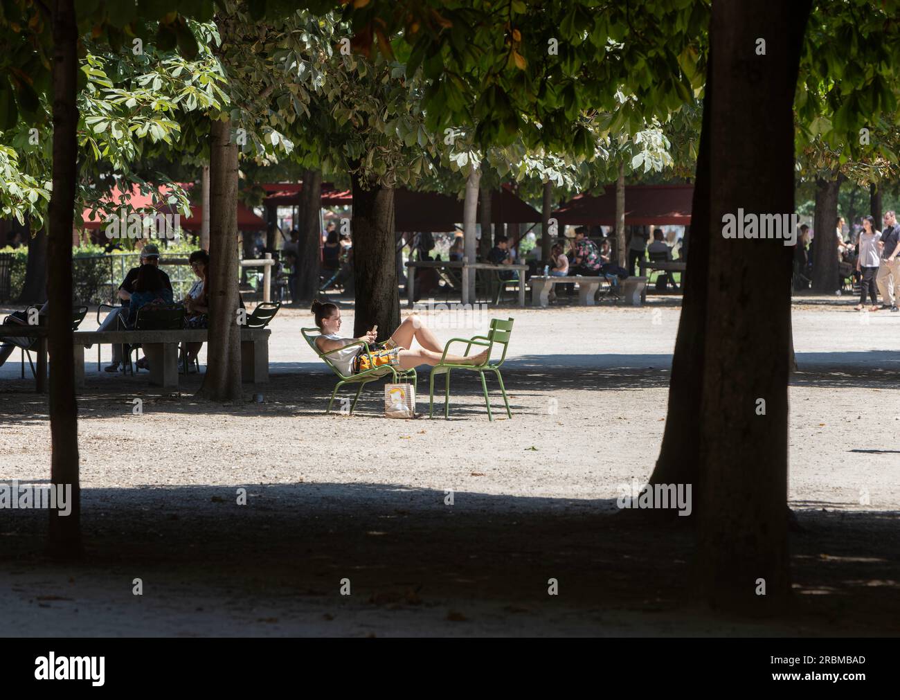 Jardin des Tuileries. Treelined avenues in 17th century Tuileries Garden give shade on sunny day for sunbathers. Place de la Concorde, 1 Arr Paris. Stock Photo