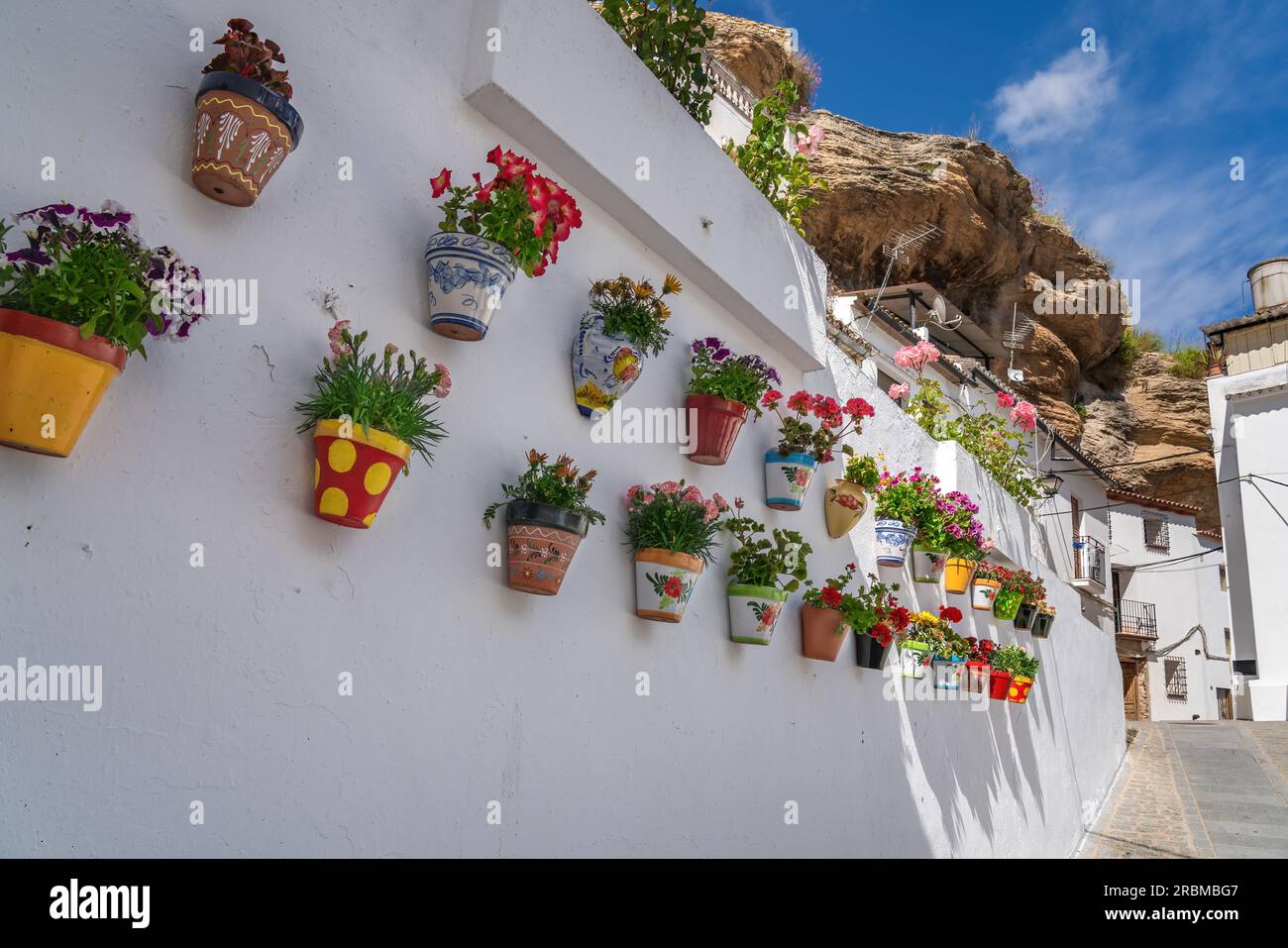 Colorful flower pots and rock overhangs - Setenil de las Bodegas, Andalusia, Spain Stock Photo