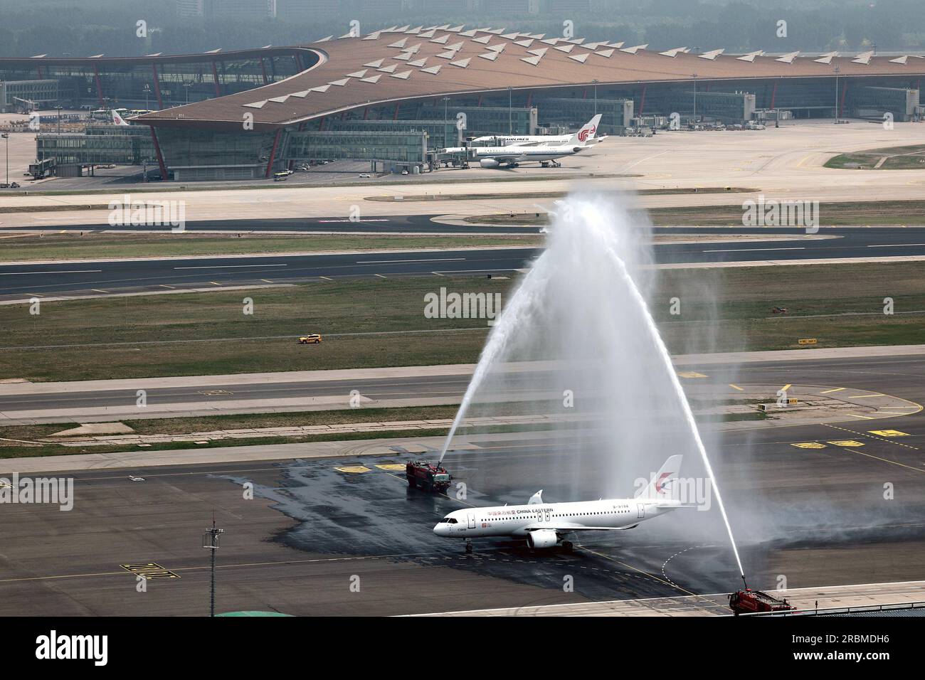 Urumqi, China. 28th May, 2023. A C919 large passenger aircraft, China's first self-developed trunk jetliner, is greeted with a water salute after touching down at Beijing Capital International Airport in Beijing, capital of China, May 28, 2023. Credit: Wang Yang/Xinhua/Alamy Live News Stock Photo