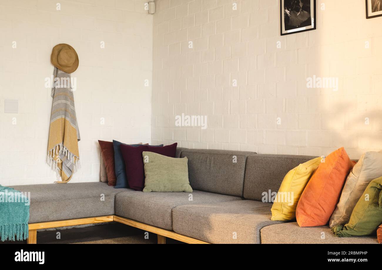 View of bright living room interior with corner sofa and cushions. Home