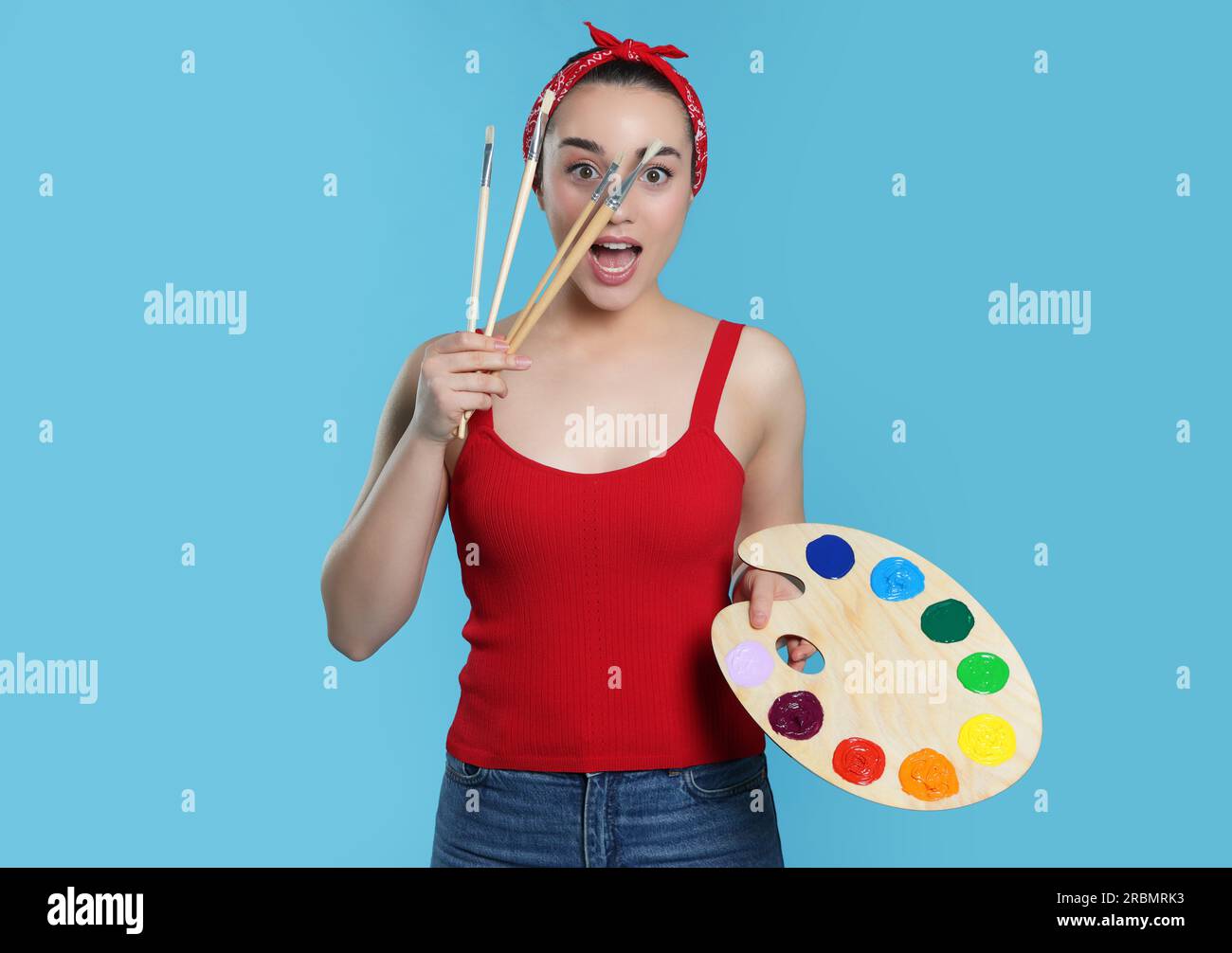 Woman with painting tools on light blue background. Young artist Stock ...