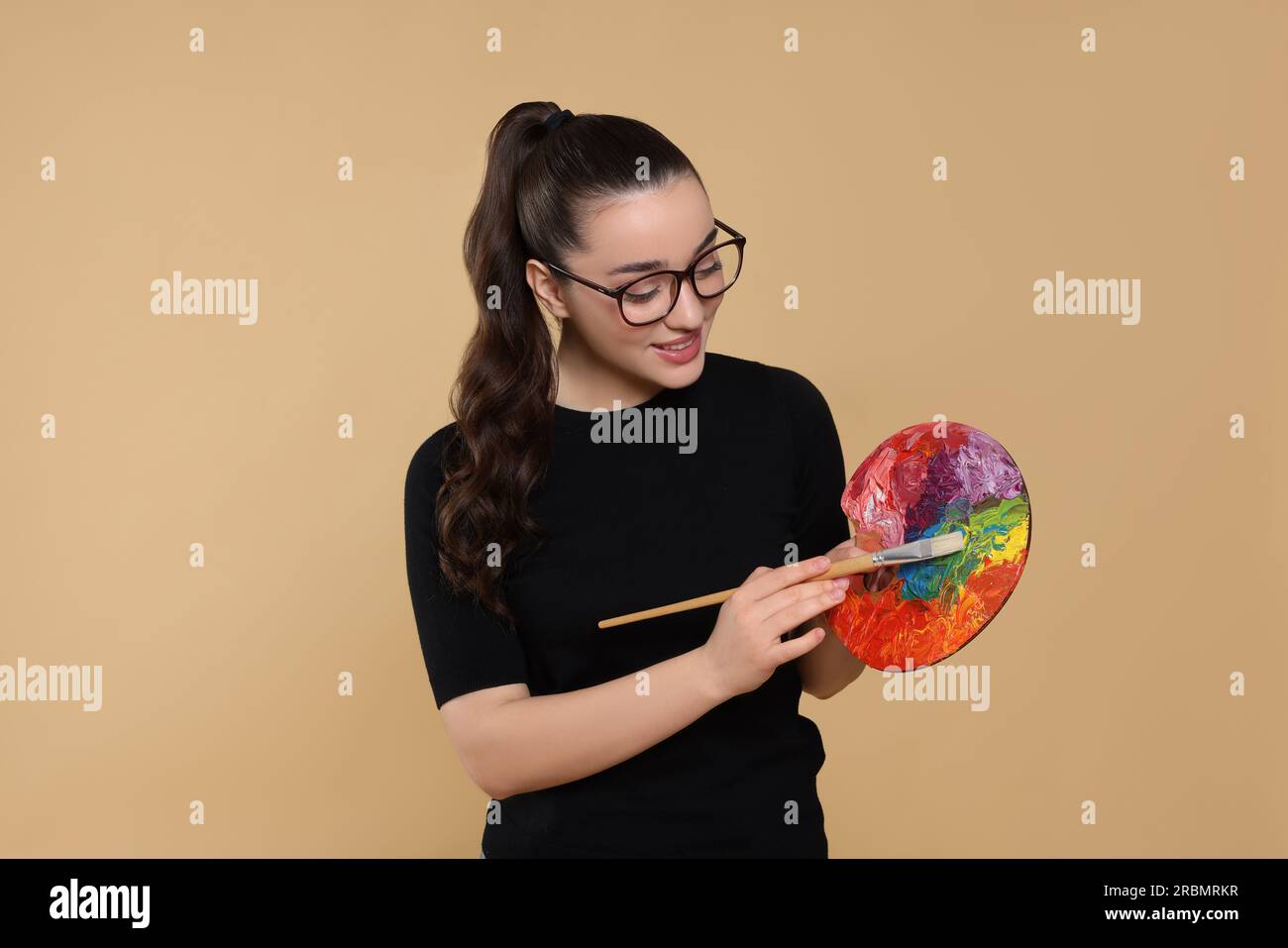 Woman with painting tools on beige background. Young artist Stock Photo ...