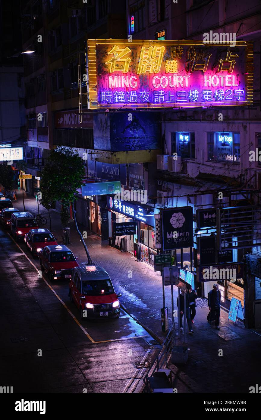 Hong Kong, China - April 28 2023: Colorful Neon light Sign of a hotel and red taxi line at night on Lockhart Road Stock Photo