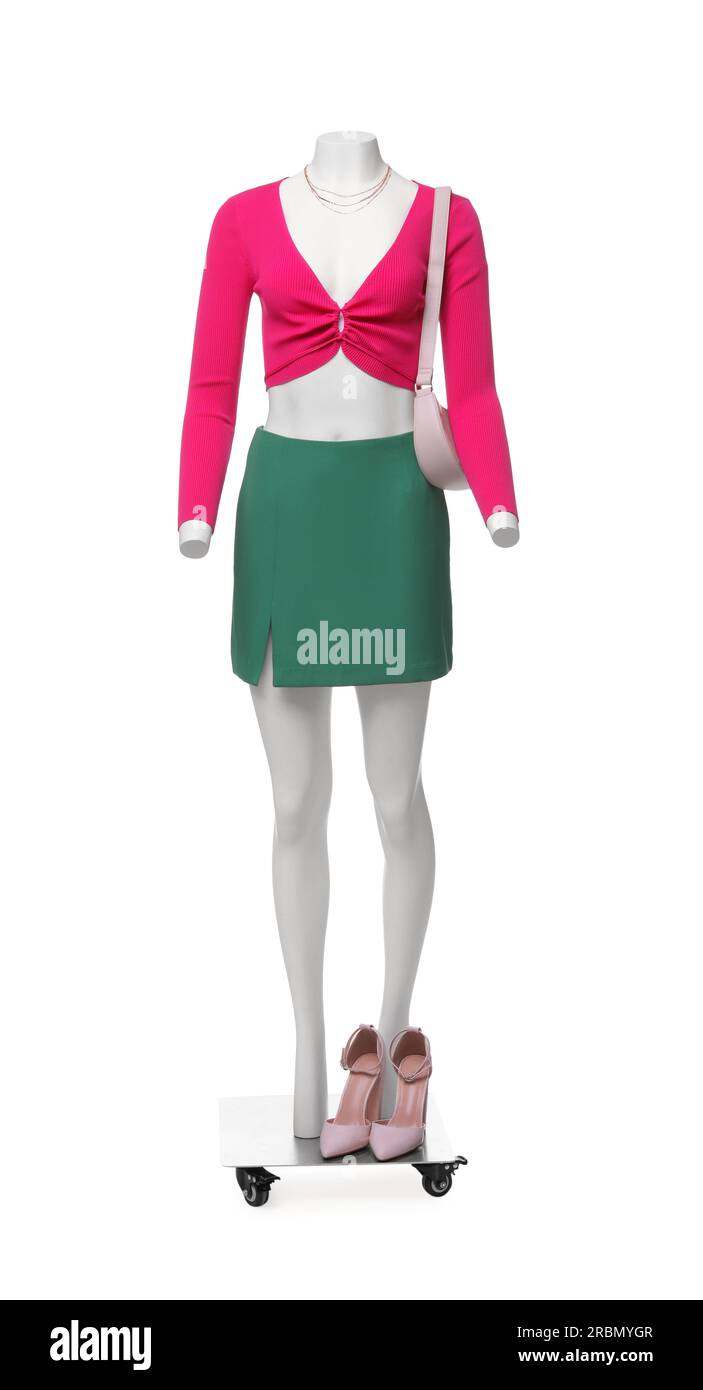 Female mannequin dressed in green skirt and pink top with accessories isolated on white. Stylish
