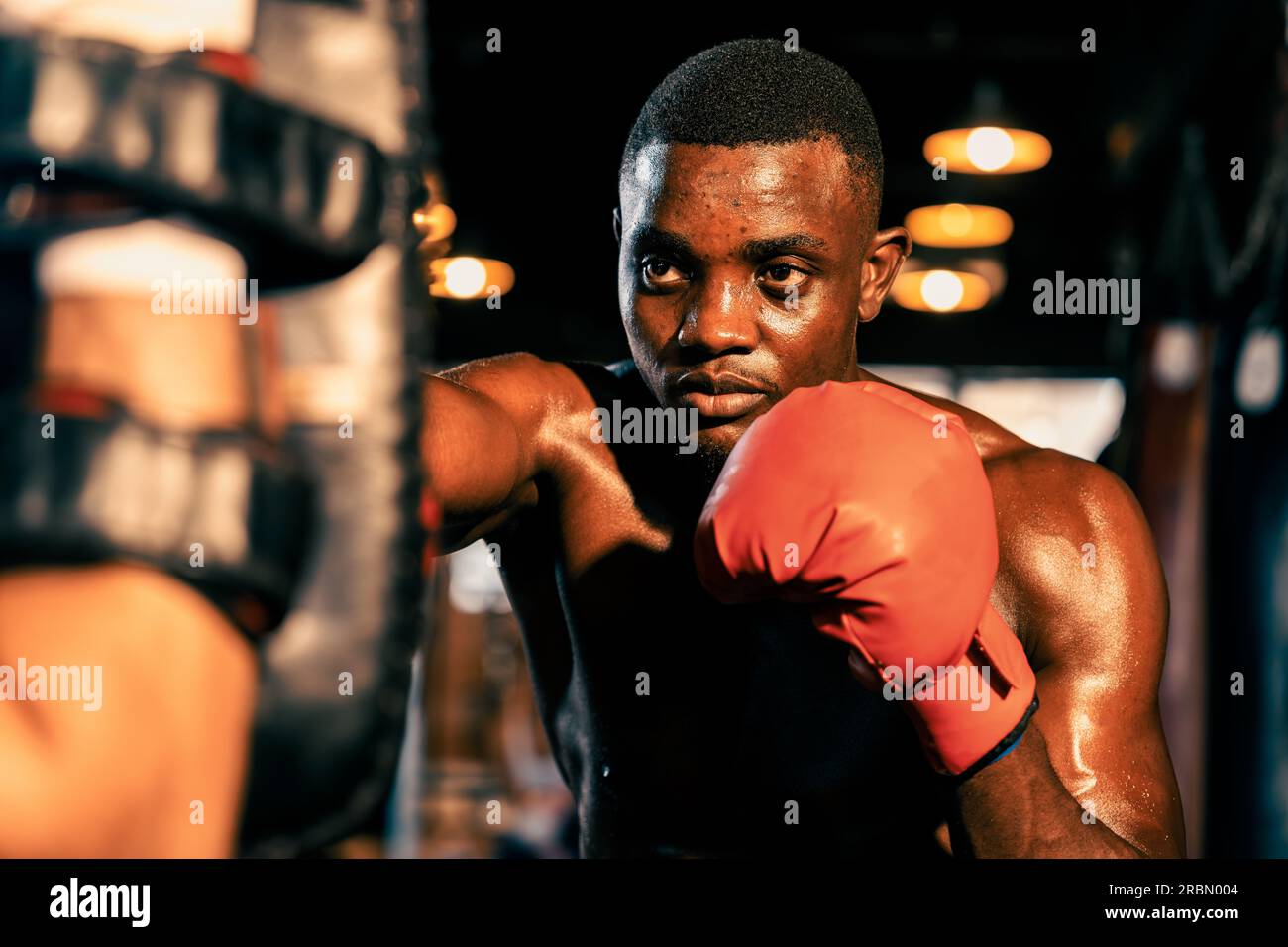 African American Black boxer punching at trainer or coach wearing