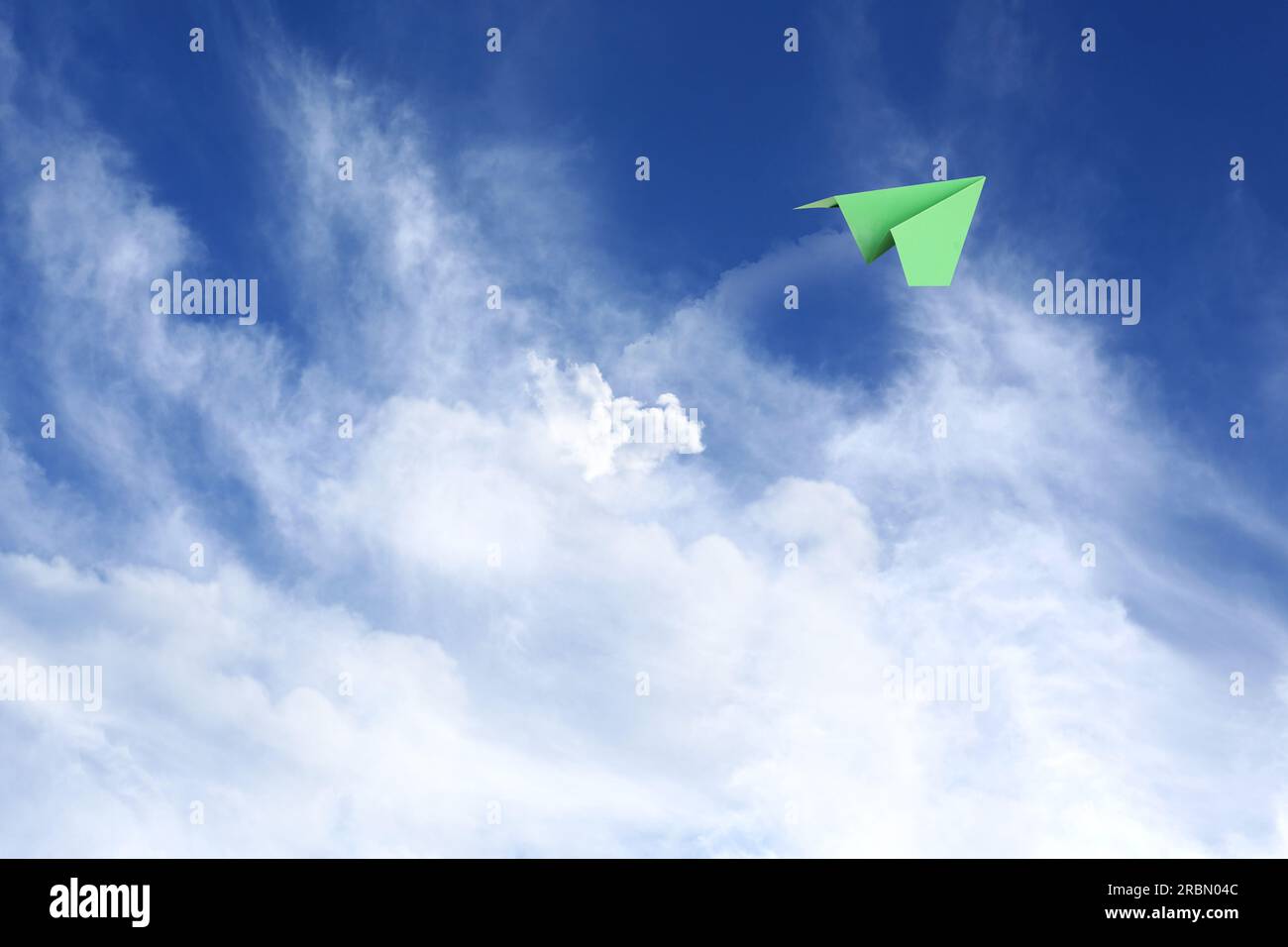 White clouds and paper airplane flying in blue sky on sunny day. Space ...