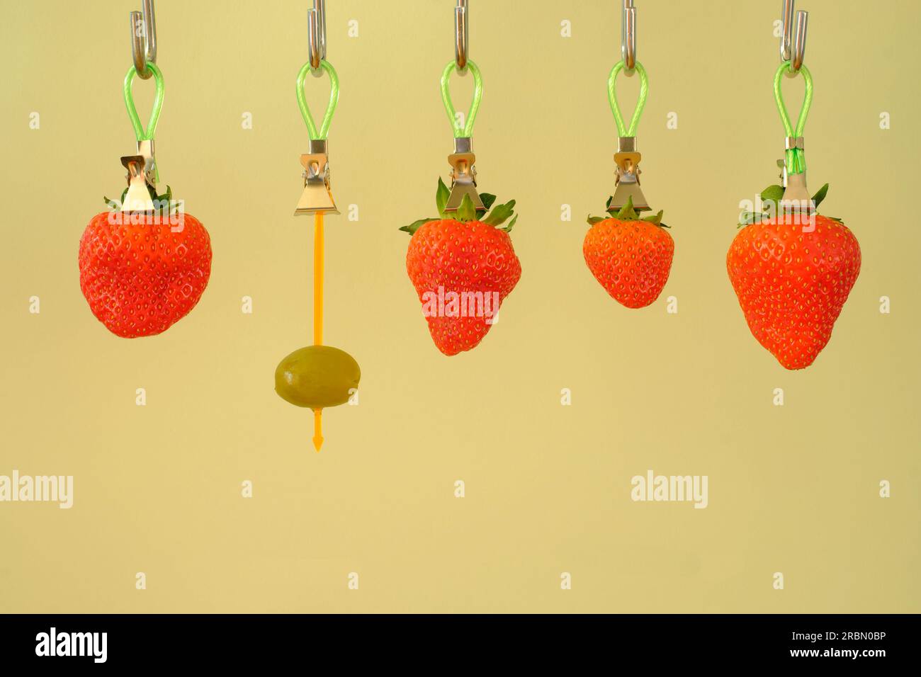 business concept, thinking outside the box, idea,unique selling point,human resources innovation,hanging strawberries with one olive Stock Photo