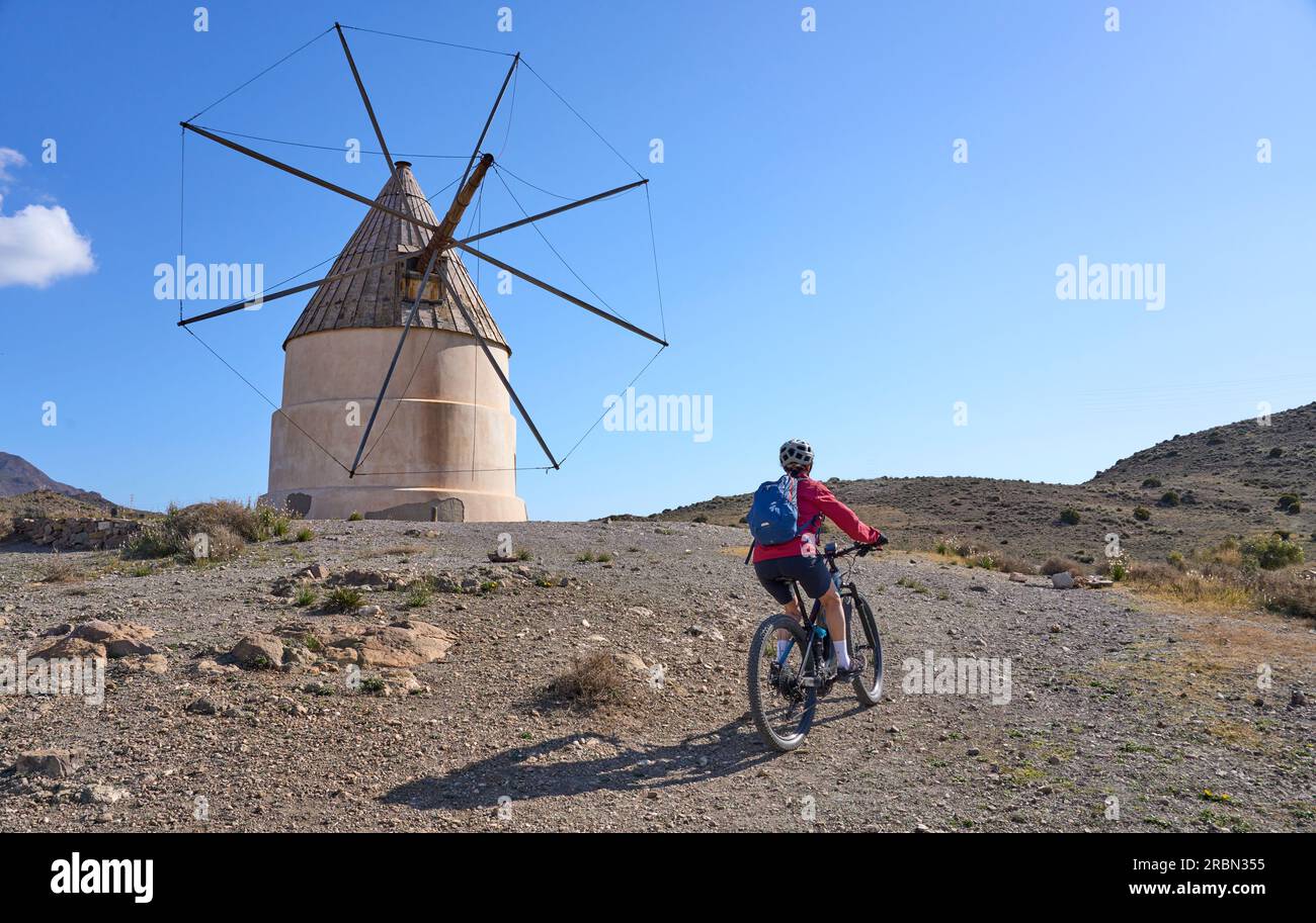 nice senior woman cycling with her electric mountain bike in the volcanic nature park of Cabo de Gata, Costa del Sol, Andalusia Stock Photo