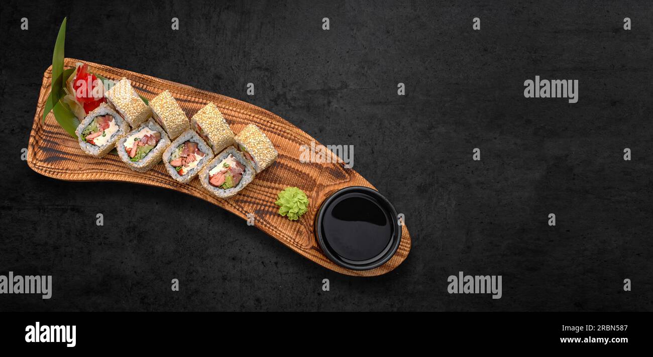 Classic sushi roll with seafood, soy sauce, wasabi and ginger. dark background, horizontal banner Stock Photo