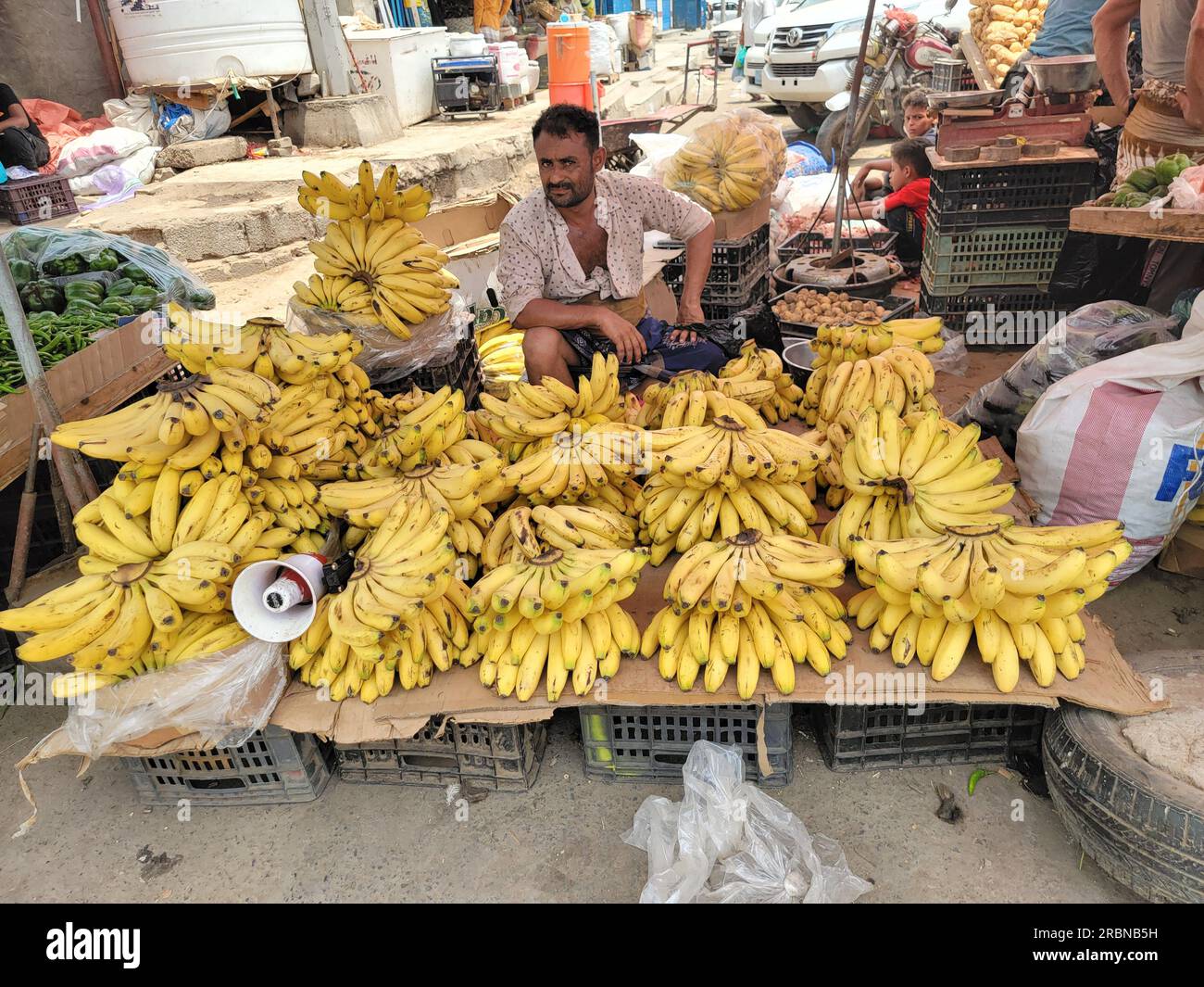 Aden, Yemen. 10th July, 2023. A vendor sells bananas at a local market in Aden, southern Yemen, on July 10, 2023. The Yemeni riyal plummeted on Sunday to a new low against the U.S. dollar, raising concerns about an impending economic crisis. Money traders in the southern port city of Aden and other government-controlled areas confirmed to Xinhua that the Yemeni riyal declined sharply to 1,430 against the greenback, marking the lowest exchange rate since the beginning of this year. Credit: Murad Abdo/Xinhua/Alamy Live News Stock Photo