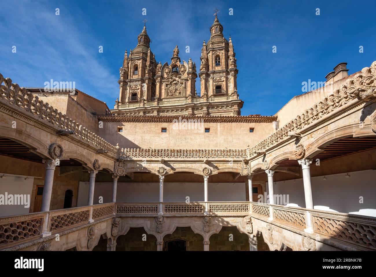 Casa de las Conchas (House of Shells) Courtyard and La Clerecia Church - Salamanca, Spain Stock Photo