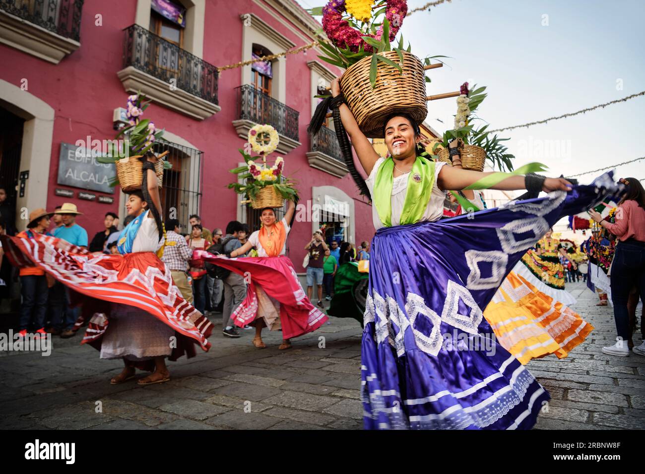 Women with skirts (traditionally dressed indigenous people) dance through the old town of Oaxaca de Juárez, Oaxaca State, Mexico, North America, Latin Stock Photo