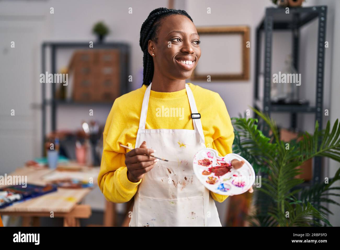 African american woman artist smiling confident holding paintbrush and ...