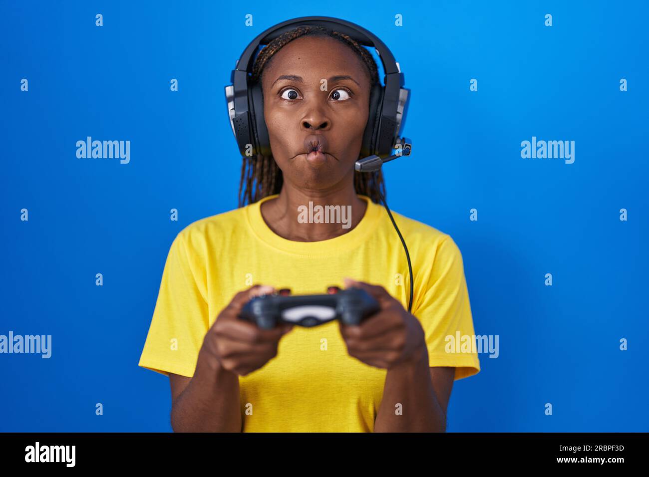 African american woman playing video games making fish face with mouth and  squinting eyes, crazy and comical Stock Photo - Alamy