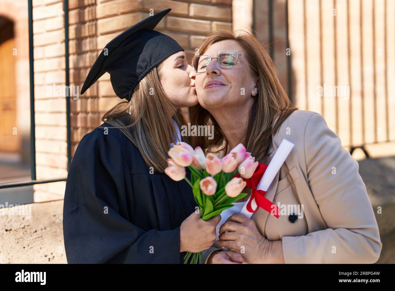 Mother And Daughter Hugging Each Other Celebrating Graduation Holding