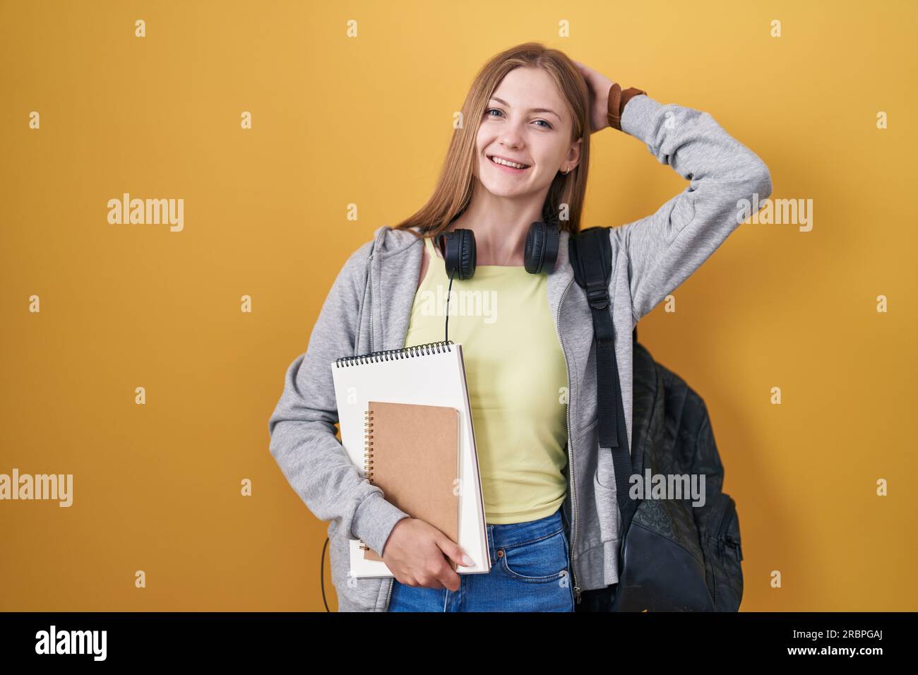 Young caucasian woman wearing student backpack and holding books ...