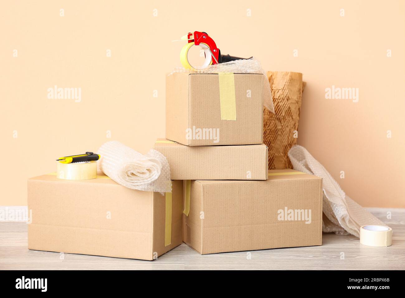 Packing tape dispenser, cardboard boxes and rolls of bubble wrap near