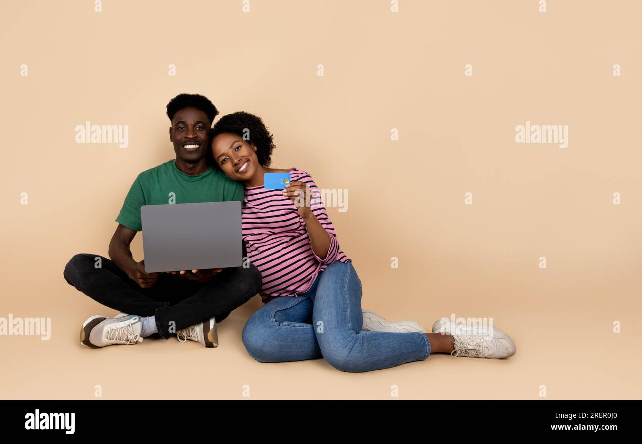 Happy millennial african american husband and wife with big belly sit ...
