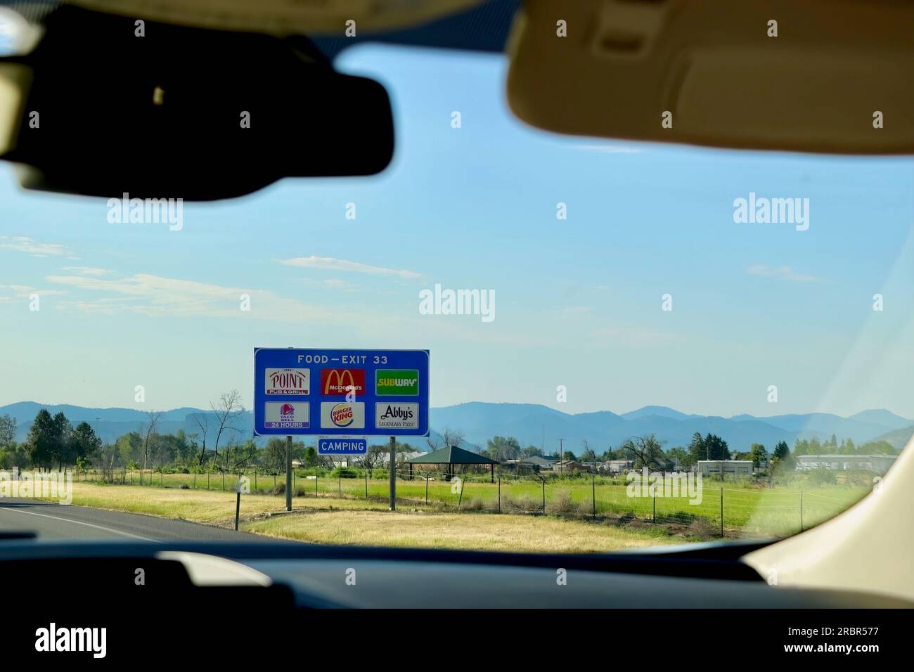 Roadside sign at Exit 33 on Interstate 5 for fast food restaurants from inside a car driving north Central Point Oregon USA Stock Photo
