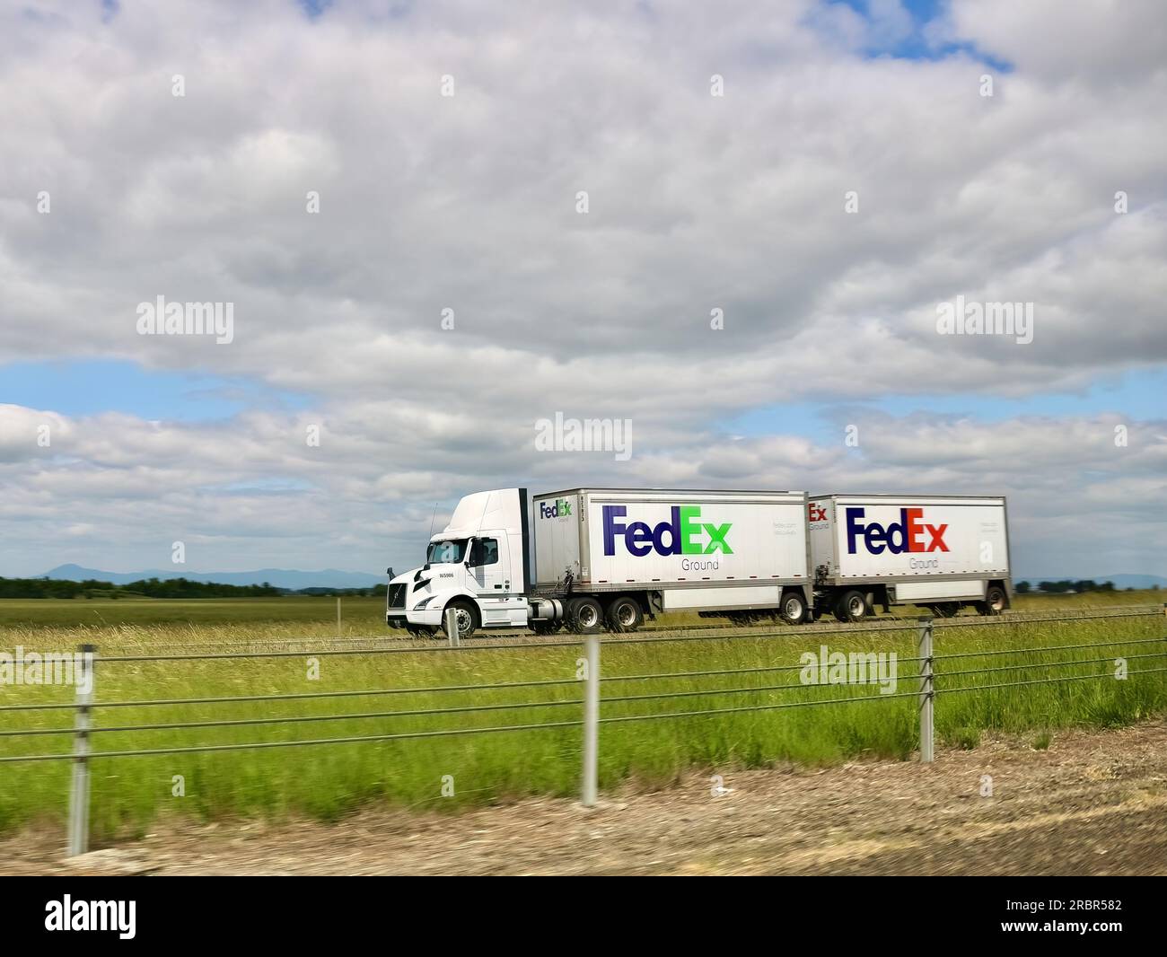 FedEx Ground Shipping low-cost package delivery truck with twin trailers driving south on Interstate 5 Oregon USA Stock Photo