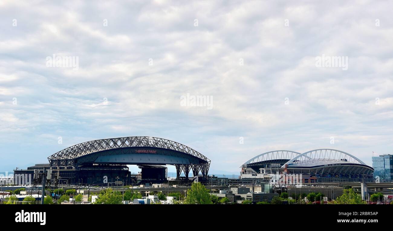 View from inside a car driving north on the I-5 of the Lumen Field stadium and T-Mobile Park stadium in the distance Seattle Washington State USA Stock Photo