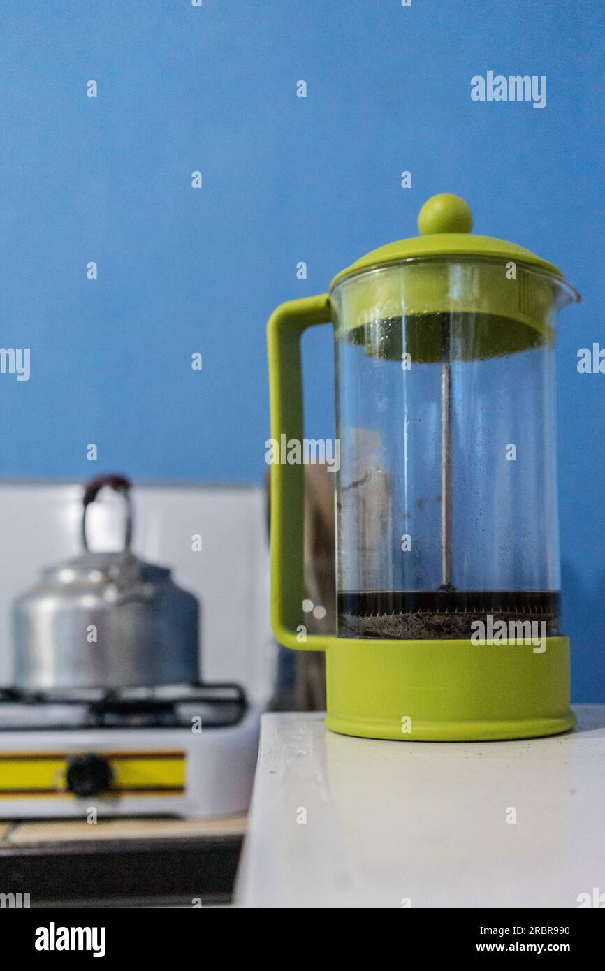 https://c8.alamy.com/comp/2RBR990/plastic-bodum-french-press-on-a-white-counter-with-kettle-on-a-gas-cooktop-behind-it-in-jinotega-nicaragua-2RBR990.jpg