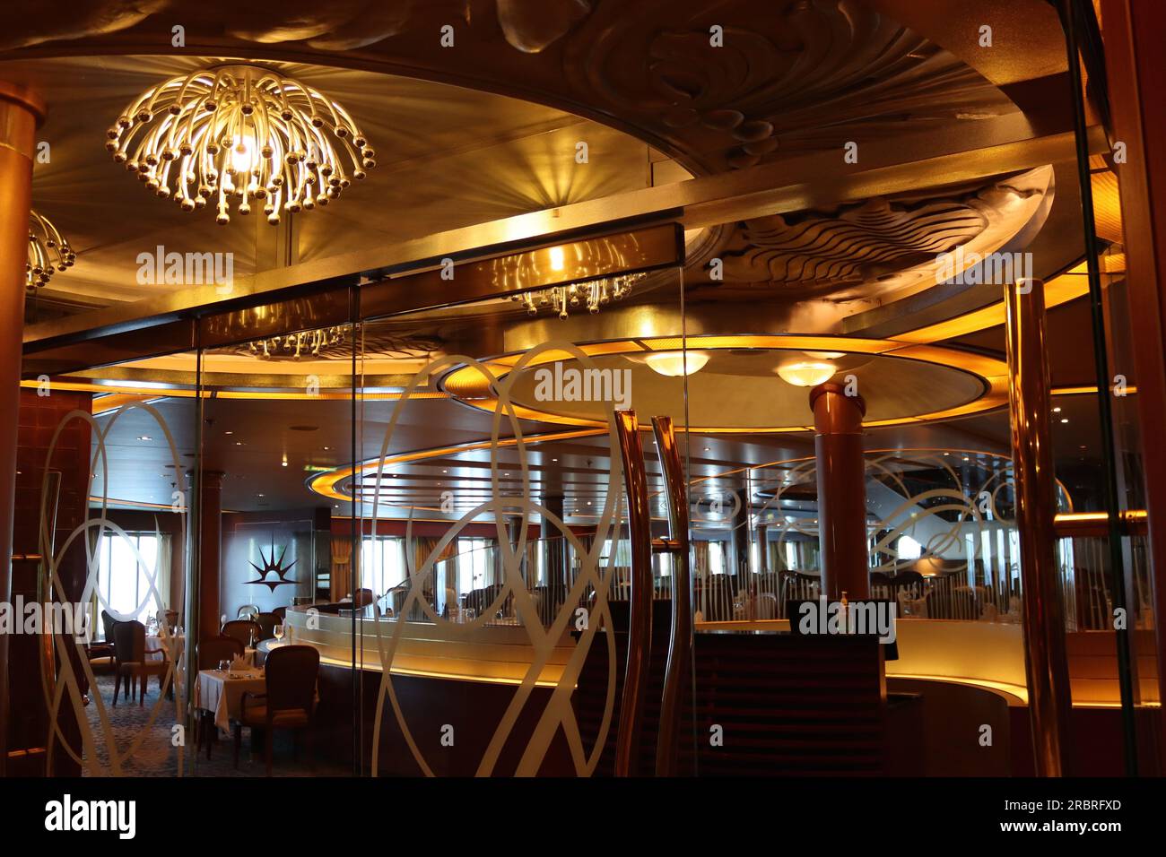 The main entrance to the Meridian restaurant MDR - Main Dining Room, on deck 2- F deck, looking astern aboard the P&O cruise ship Arcadia, April 2023. Stock Photo