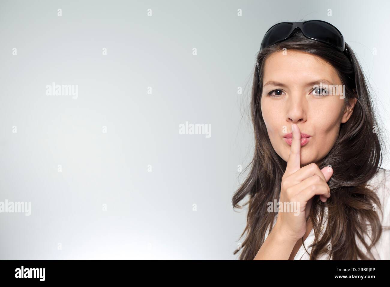 Woman putting her finger to her lips for shhh gesture Stock Photo