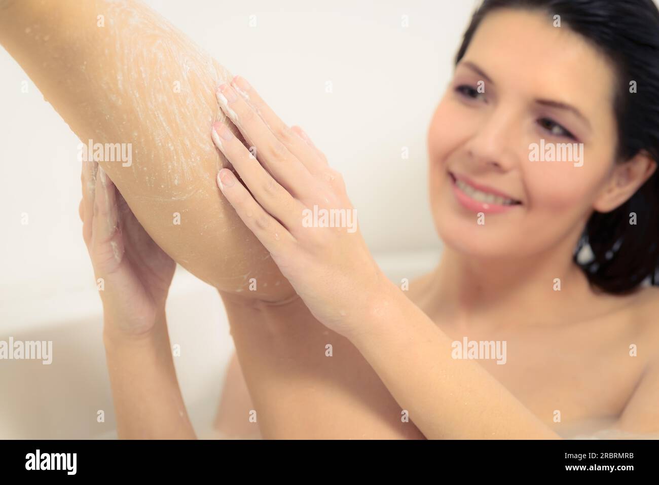 Young woman enjoying a relaxing bath soaping her skin to wash away the dirt from her days activities as she cares for her skin in a personal hygiene Stock Photo