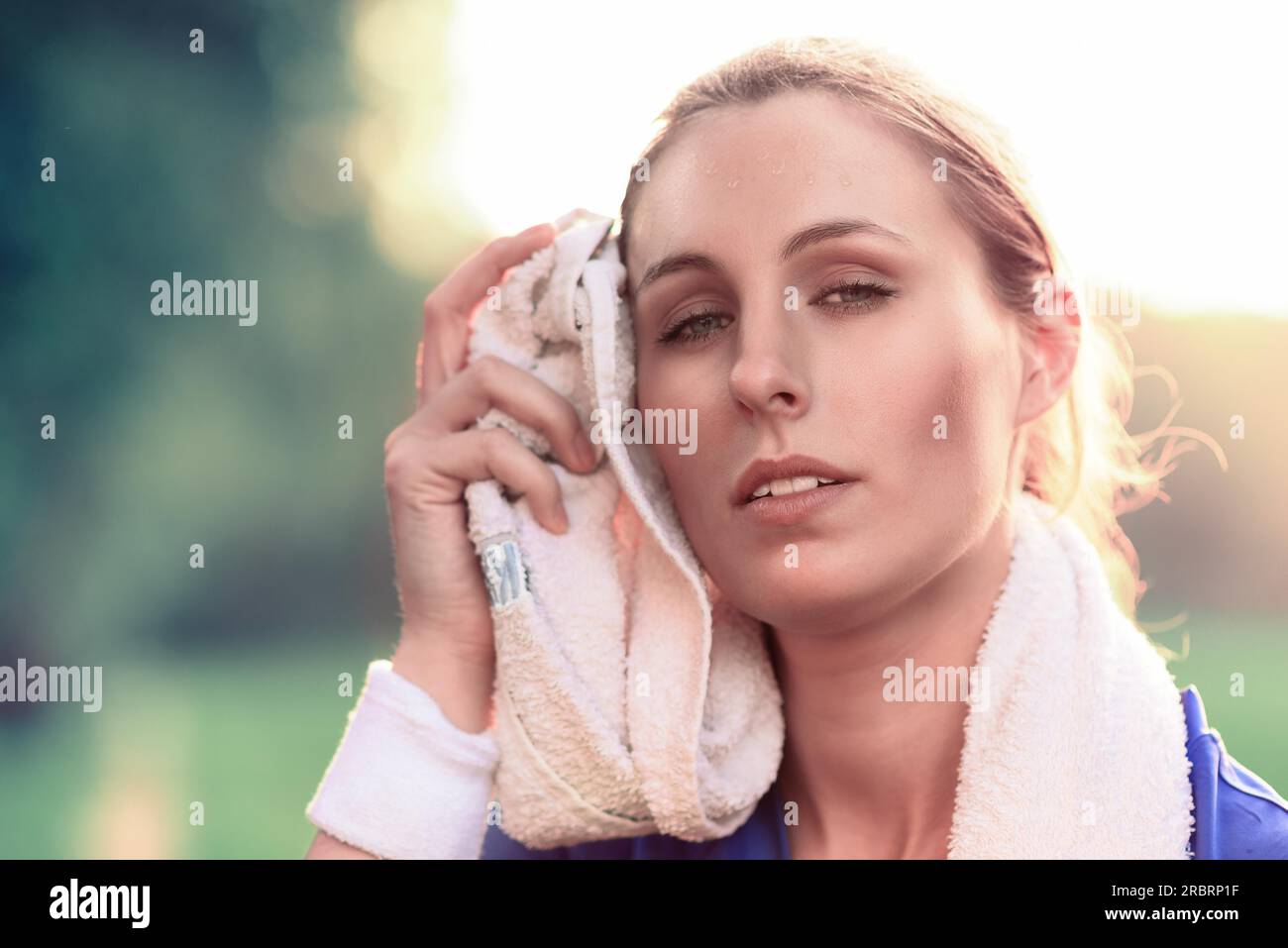 Close up Middle Age Woman Wiping Face Sweats with White Towel After