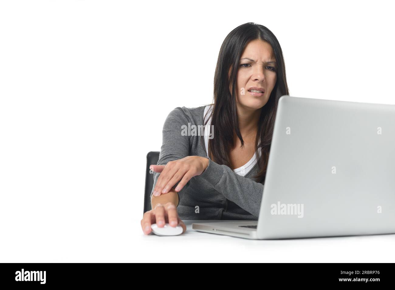 Young businesswoman rubbing and massaging her forearm to relieve cramps after using a computer mouse for too long at a stretch, on white Stock Photo