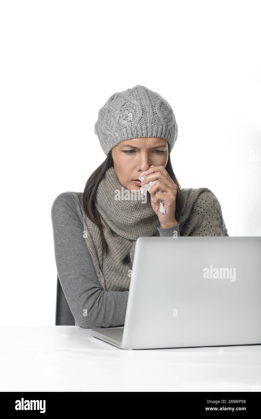 Young businesswoman with a seasonal cold and flu sitting behind her ...