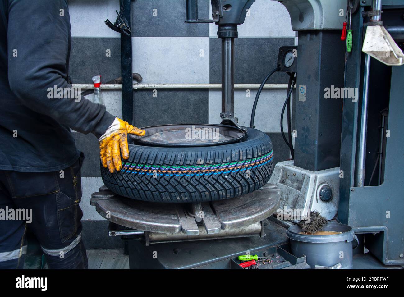 Serviceman attaches new wheel to rim Stock Photo